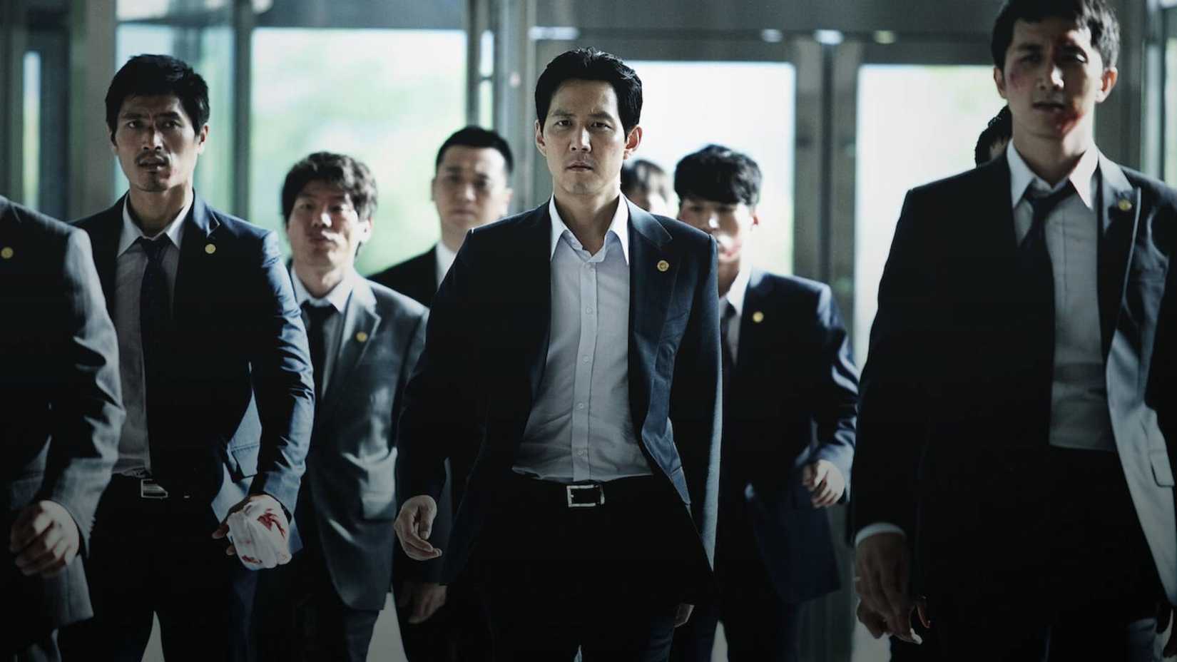 Men in suits walk towards the camera in New World (2013)