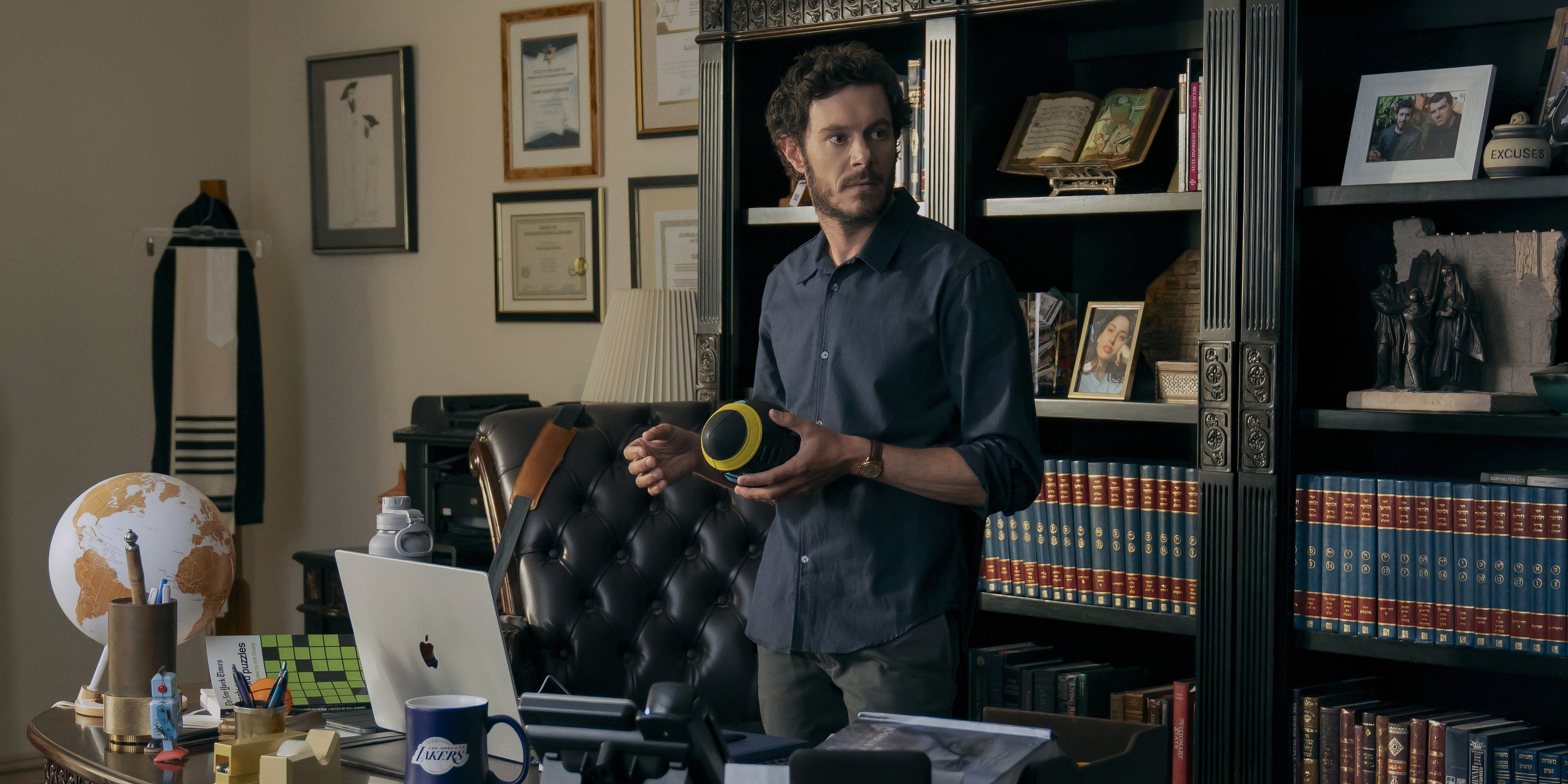 Noah holds a football while standing in his office in Netflix's Nobody Wants This