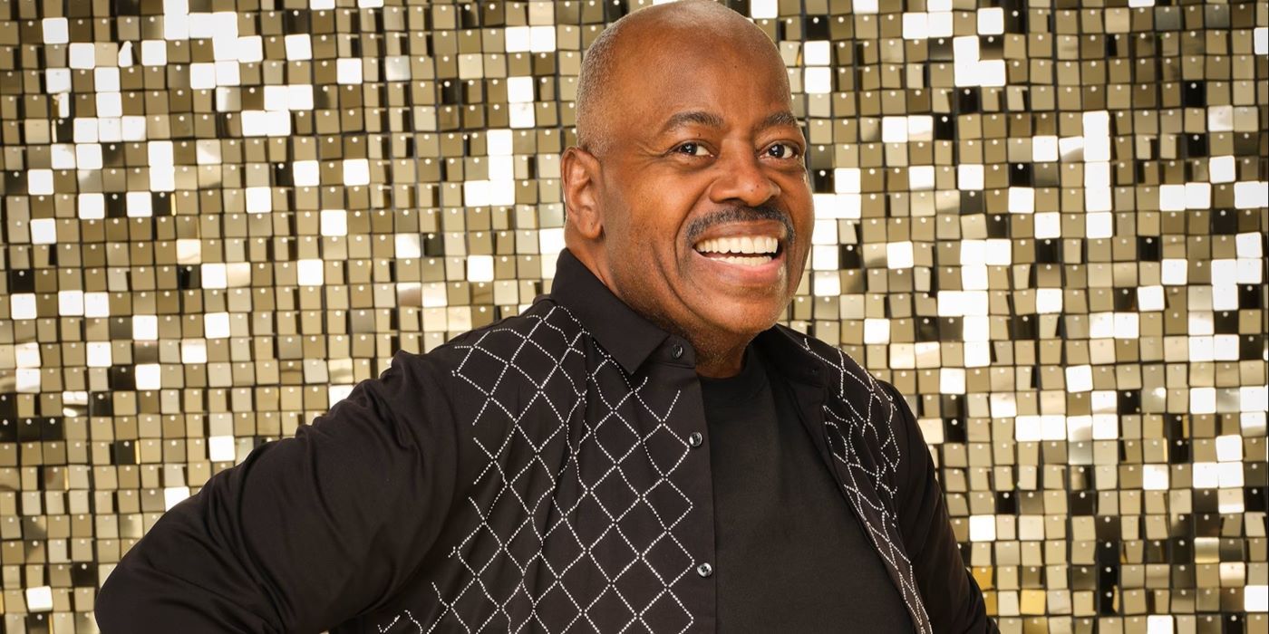 Reginald VelJohnson for Dancing with the Stars wearing a black ballroom dancing outfit smiling brightly