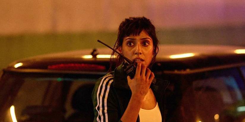 Ritu Arya as Zara looking worried and talking into a walkie talkie in Paris Has Fallen