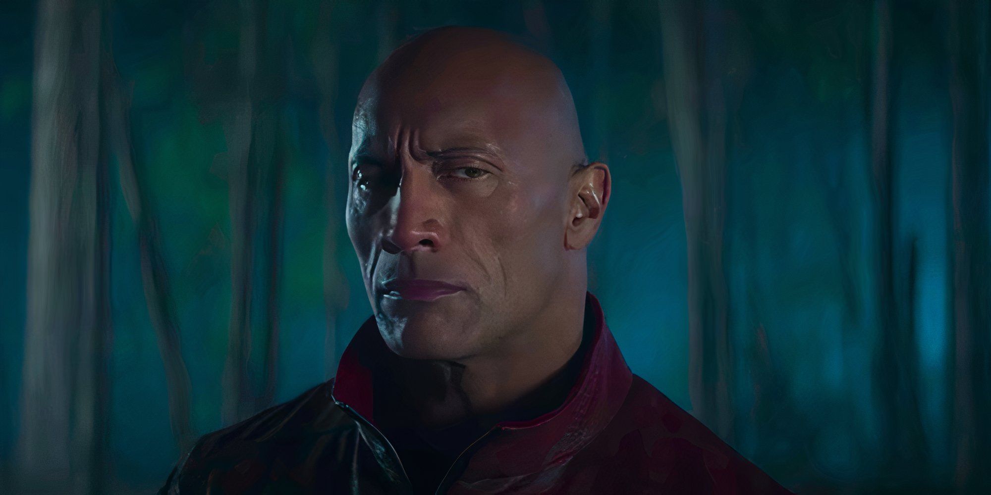 Dwayne Johnson looking serious in a forest in Red One