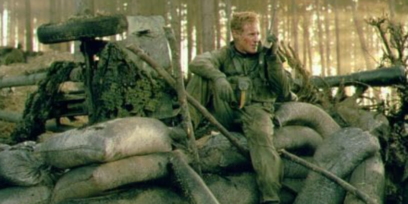Owen Wilson as Chris Burnett sitting by sandbags in Behind Enemy Lines.