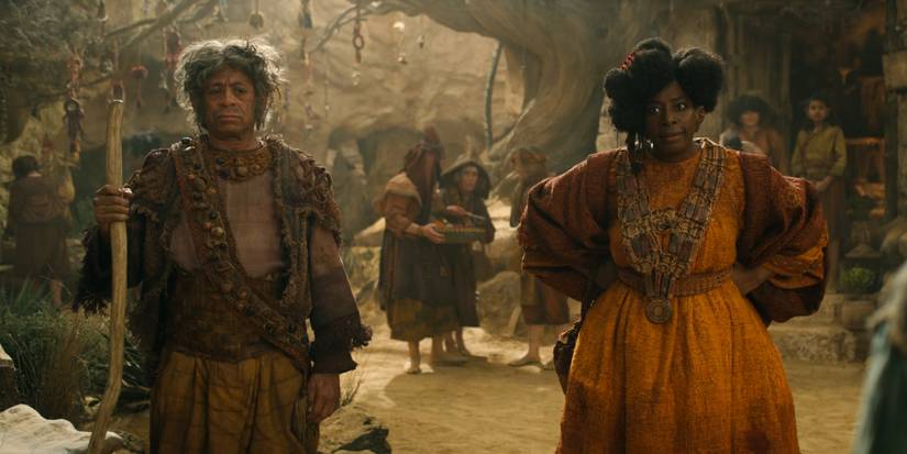 Gundabale com as mãos nos quadris e Marmadas com sua bengala na vila dos Stoors em Os Anéis de Poder (2024)