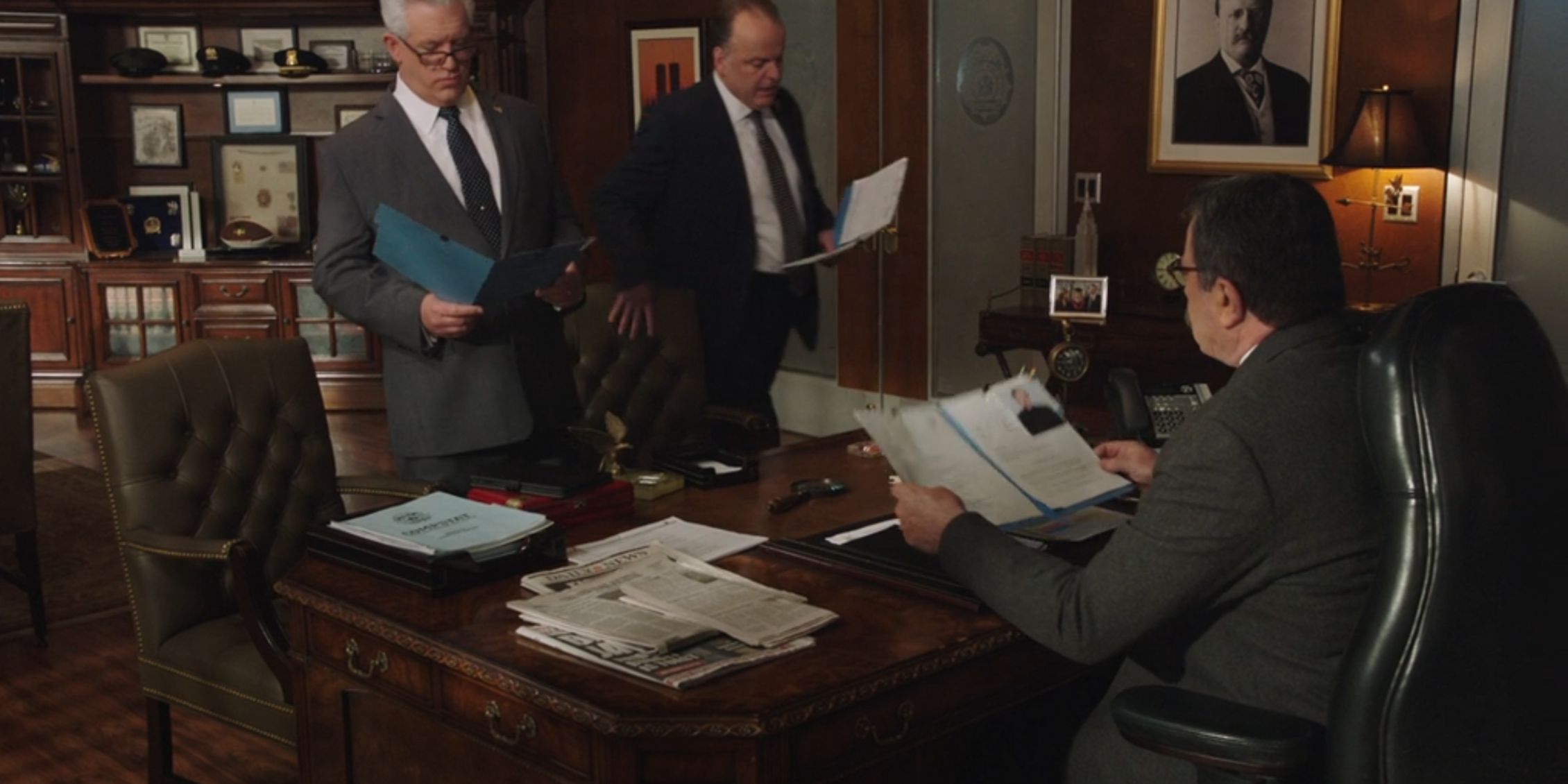 Garrett and Sid come into Frnak's office holding copies of the same report he is looking at on Blue Bloods