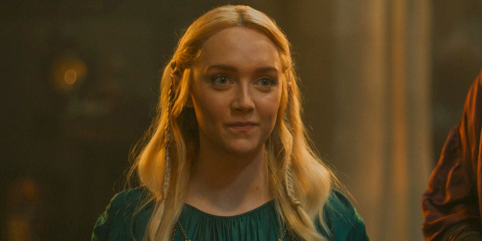 Amelia Kenworthy as Mirdania smiling and wearing green in The Rings of Power season 2