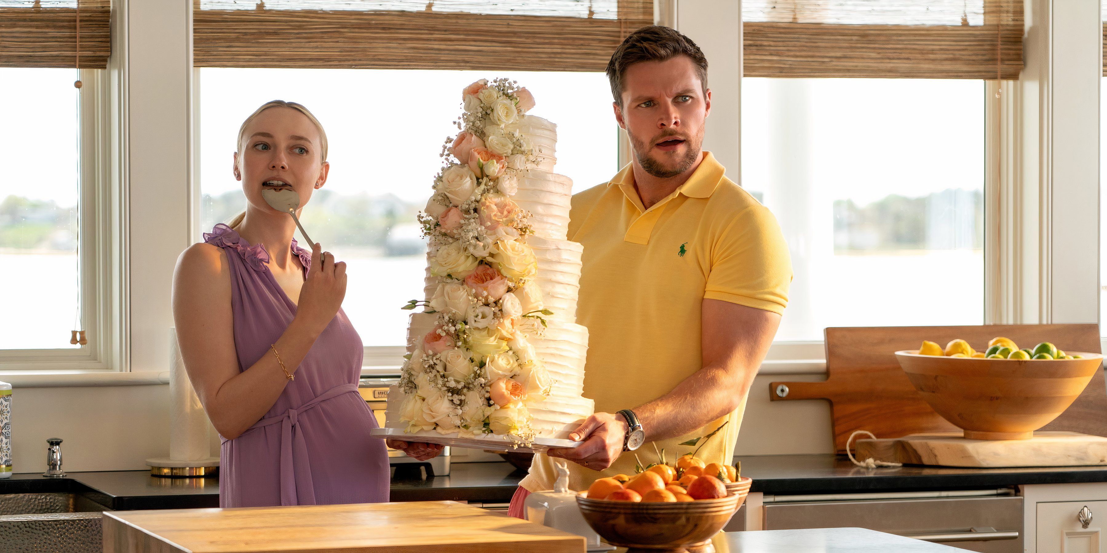 Thomas holds the wedding cake and Abby eats a spoon of it in The Perfect Couple episode 4