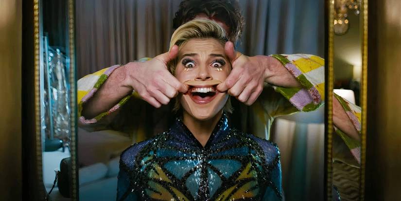 Naomi Scott como Skye Riley sendo forçada a sorrir por uma figura ensanguentada atrás dela em Smile 2