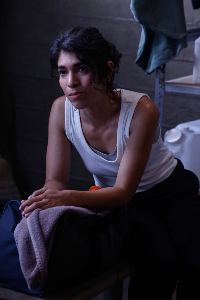Vera Strickland (Diany Rodriguez) leans forward while sitting down in NCIS Origins