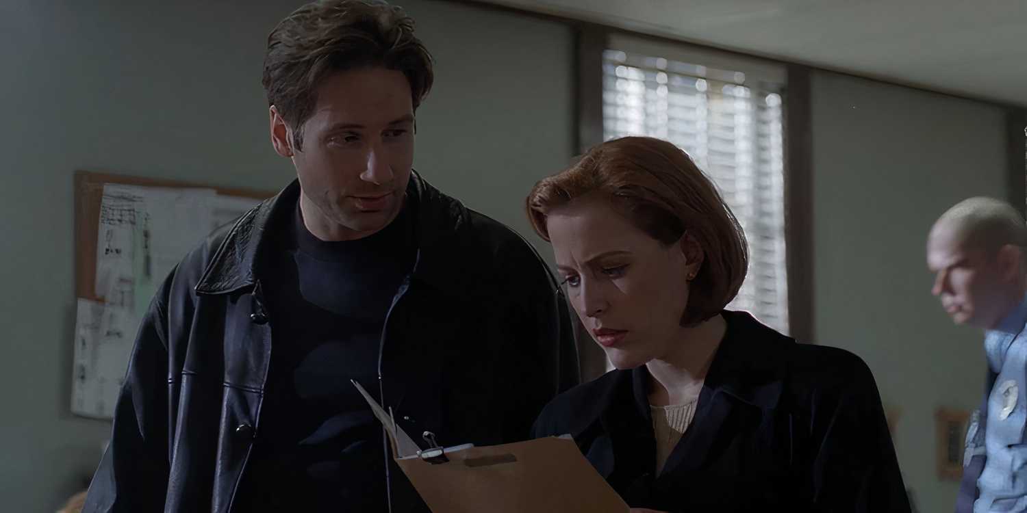 Mulder (David Duchovny) briefs Scully (Gillian Anderson) as she looks at a case file in The X-Files all souls