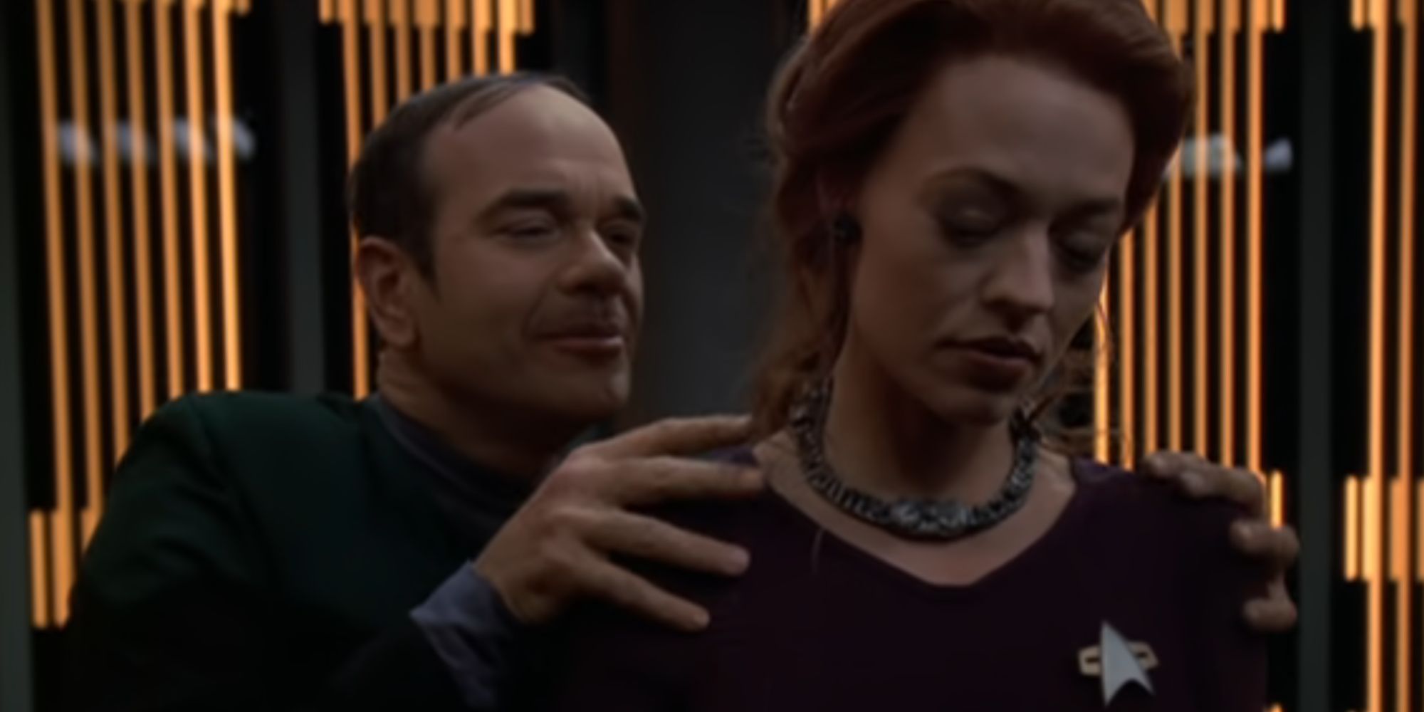 Robert Picardo as a fake version of the Doctor in Star Trek: Voyager with his hands on the shoulders of Jeri Ryan's 7 of 9
