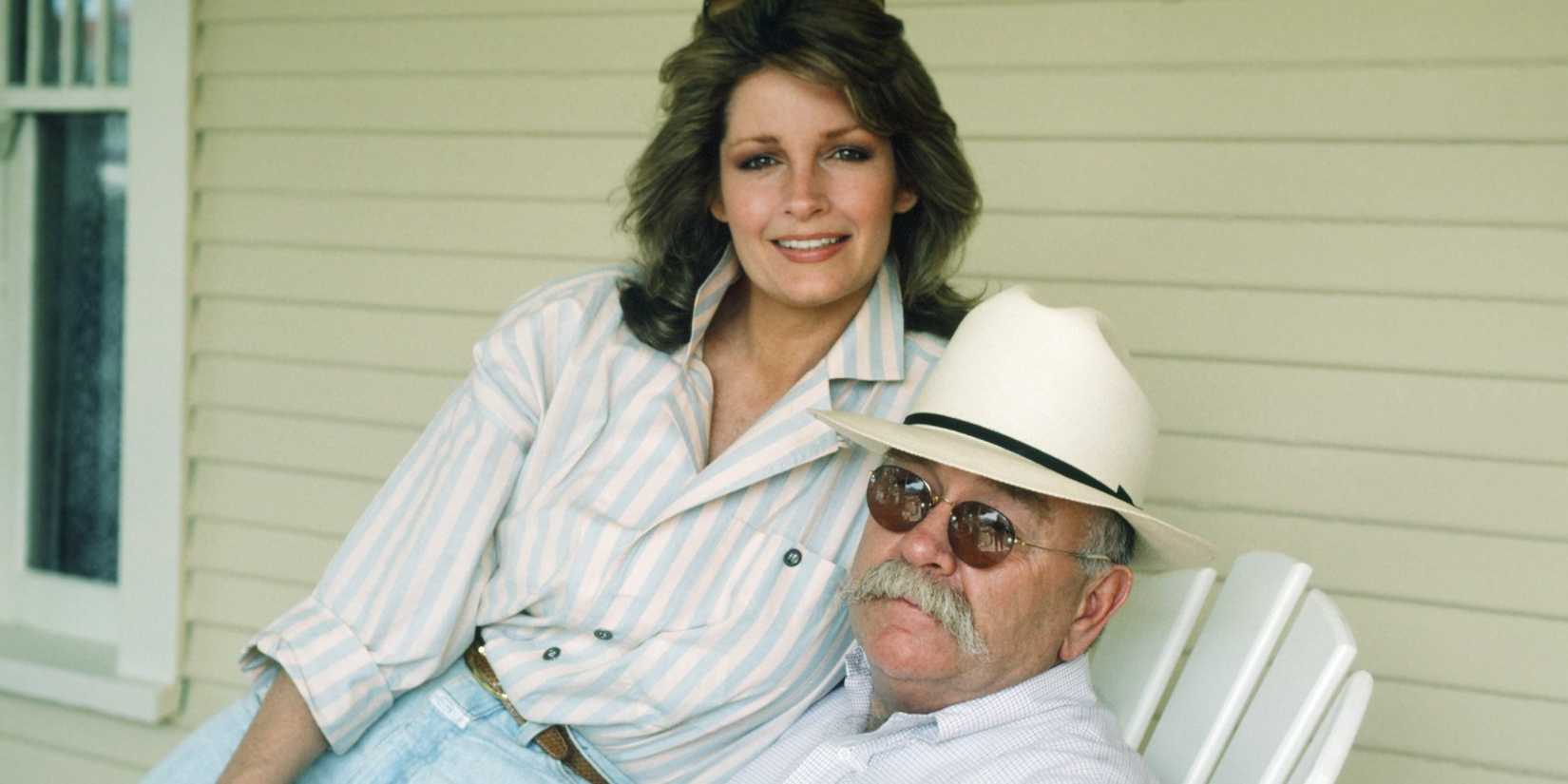 Deidre Hall on top of Wilford Brimley's lap as he sits on a porch in Our House
