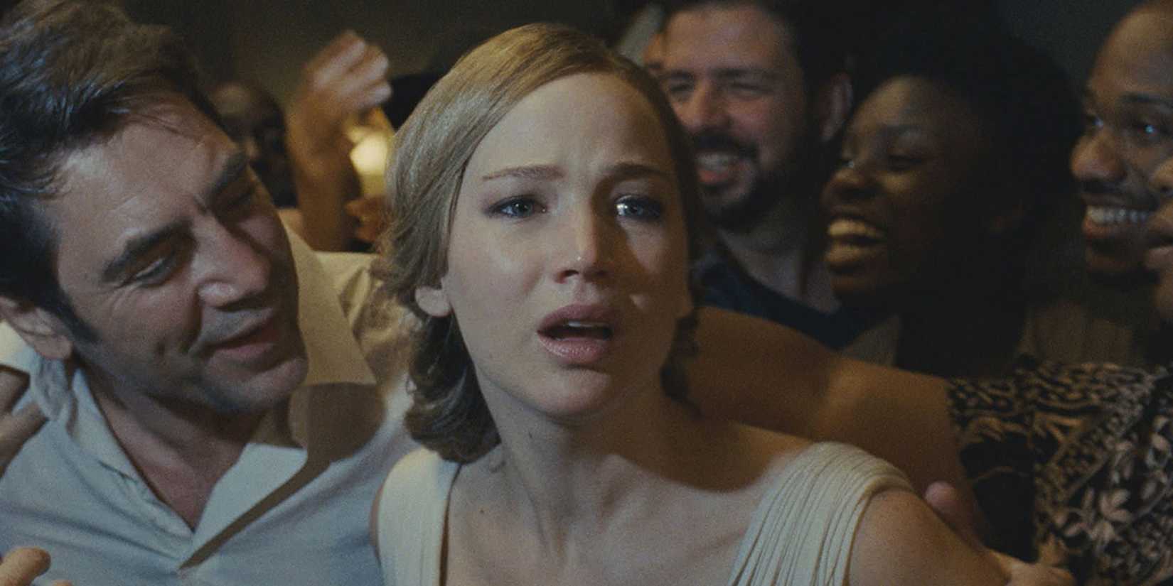 Jennifer Lawrence is being grabbed by several people including Javier Bardem, she looks frightened in the movie Mother!