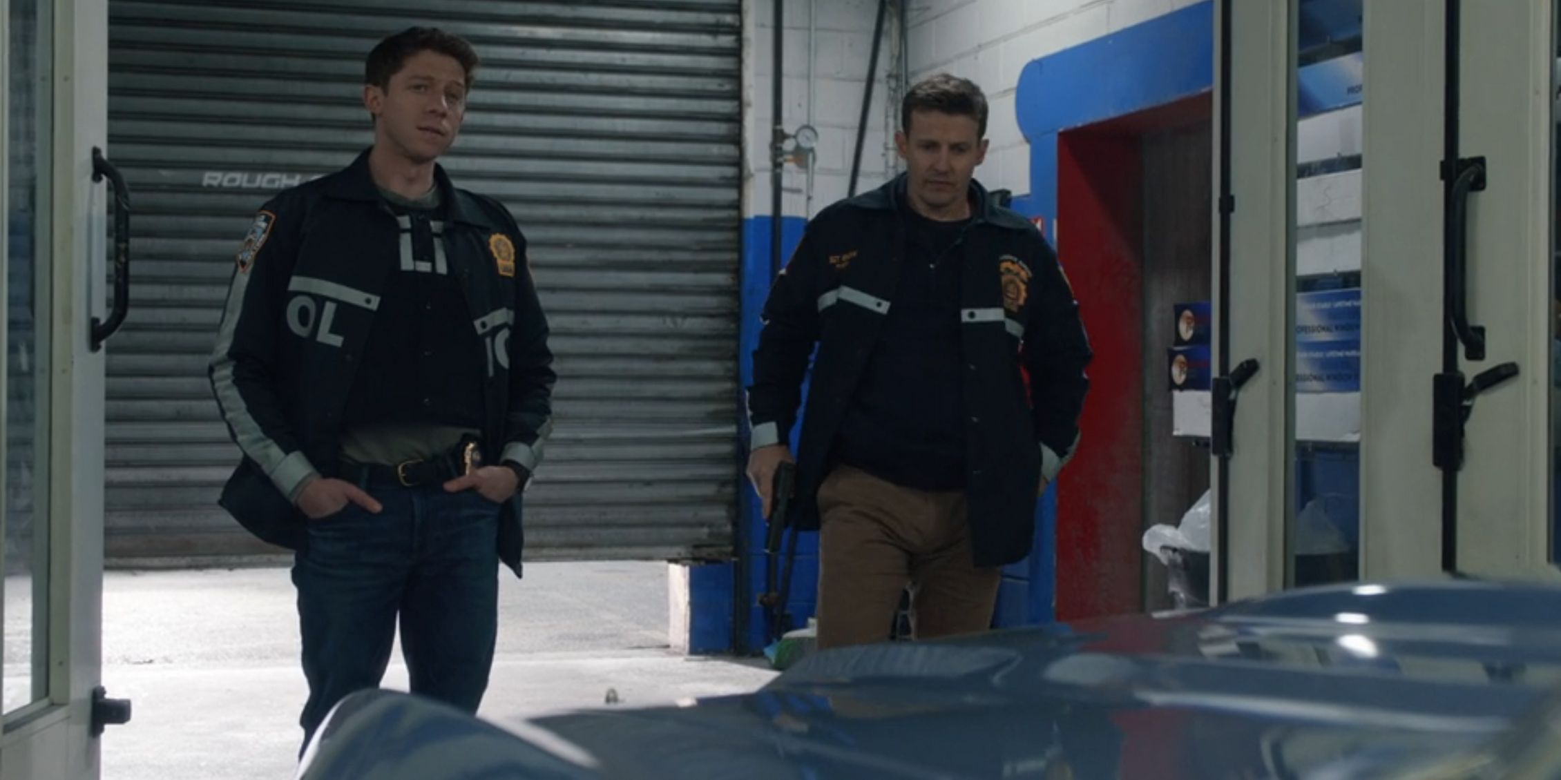 Blue Bloods Jamie and Joe standing in the garage where the stolen car was taken