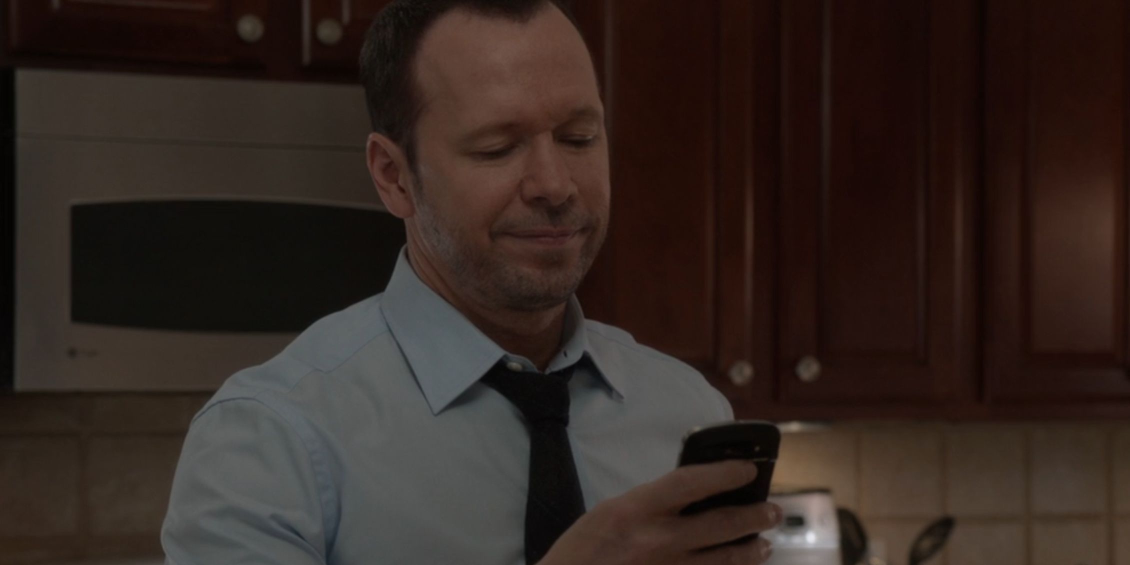 Blue Bloods Danny smiles at something on his phone