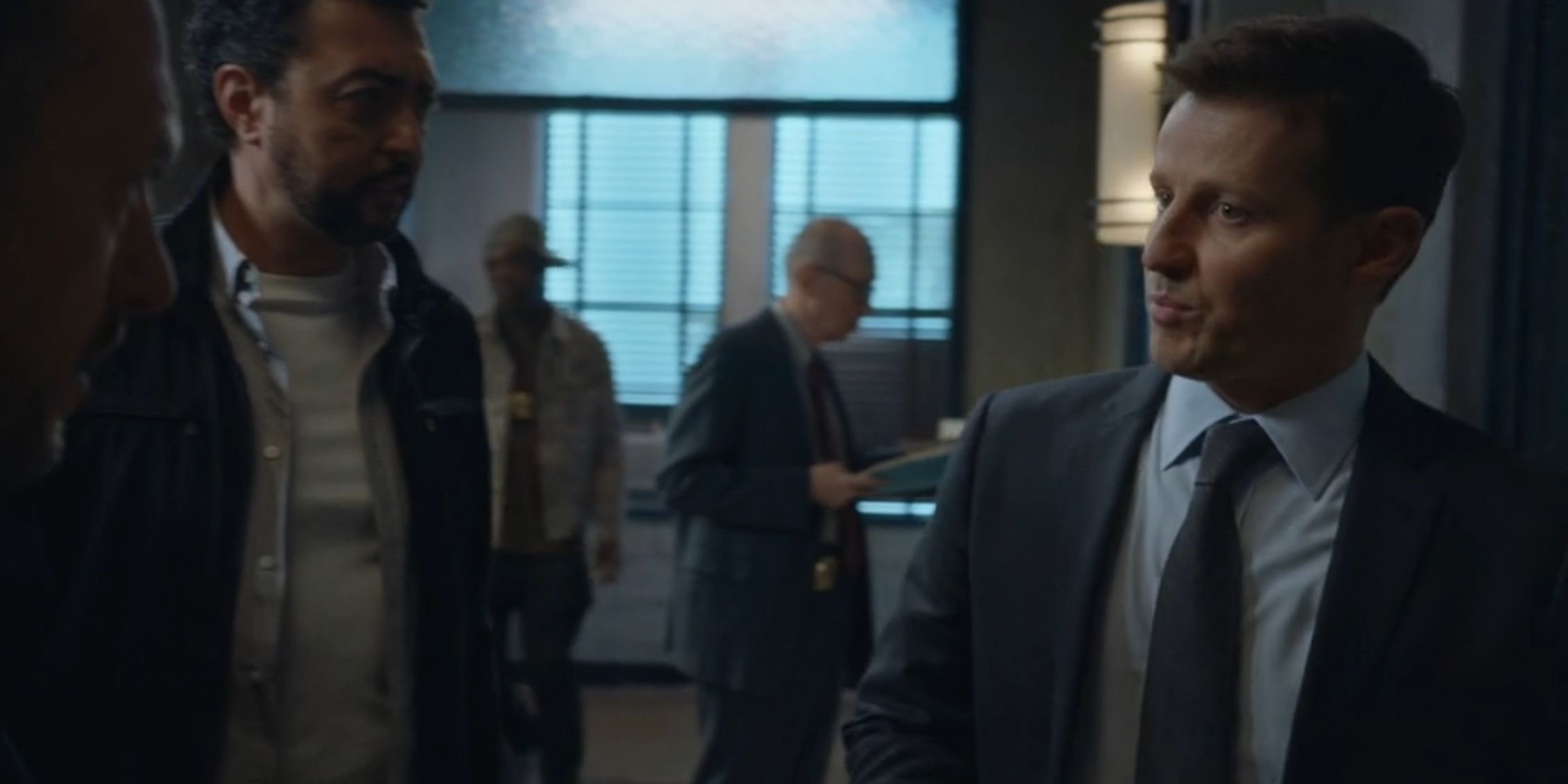 Blue Bloods Jamie looks skeptical as he walks a guy into the interrogation room 