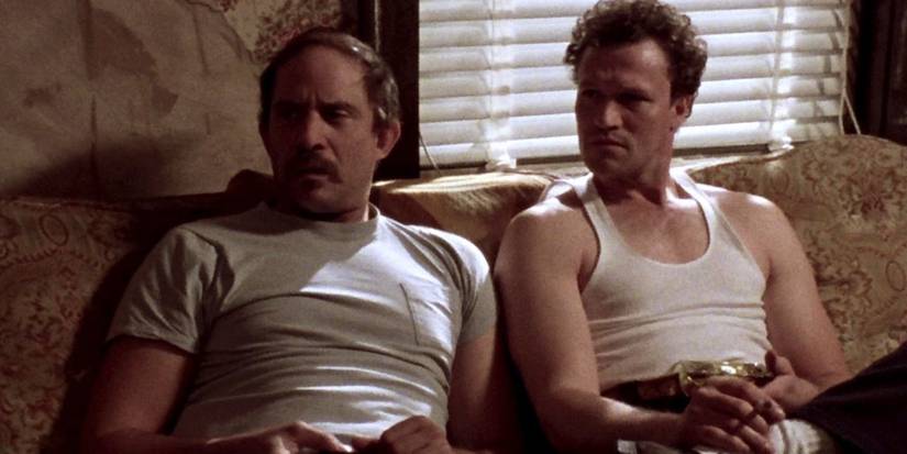 Henry and Otis sit together on a couch in Henry: Portrait of a Serial Killer