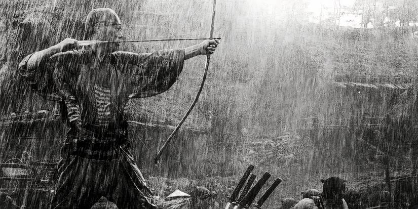 A man shoots a bow and arrow in the rain in Seven Samurai