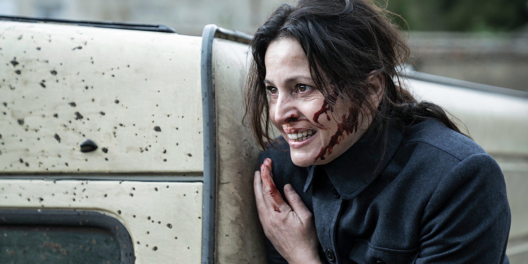 Anne Charrier as Genet leaning against a car and bleeding in Walking Dead Daryl Dixon season 2.