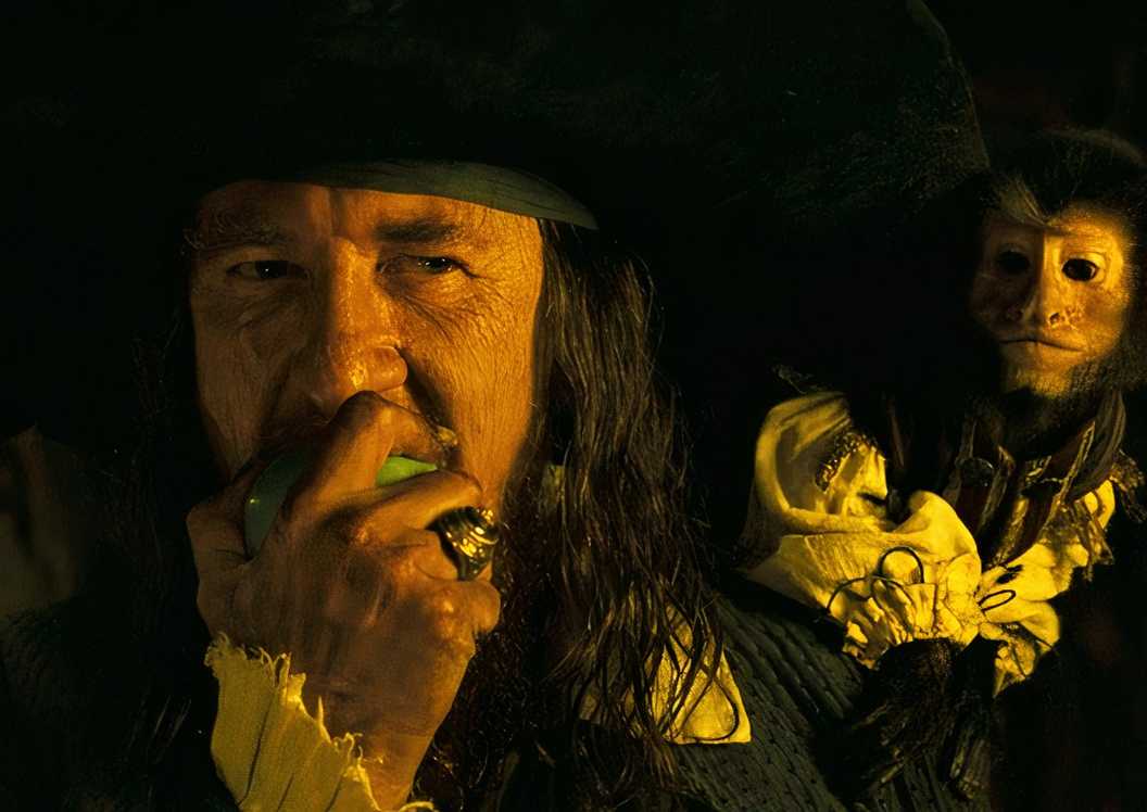 Captain Barbossa (Geoffrey Rush) biting an apple with the monkey on his shoulder at the end of Pirates of the Caribbean: Dead Man's Chest