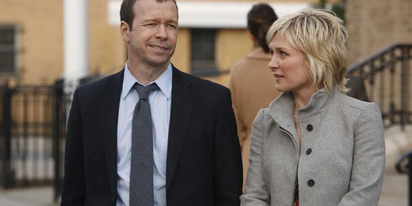 Blue Bloods Danny in a suit walking on a city street next to LInda in a gray button-up coat