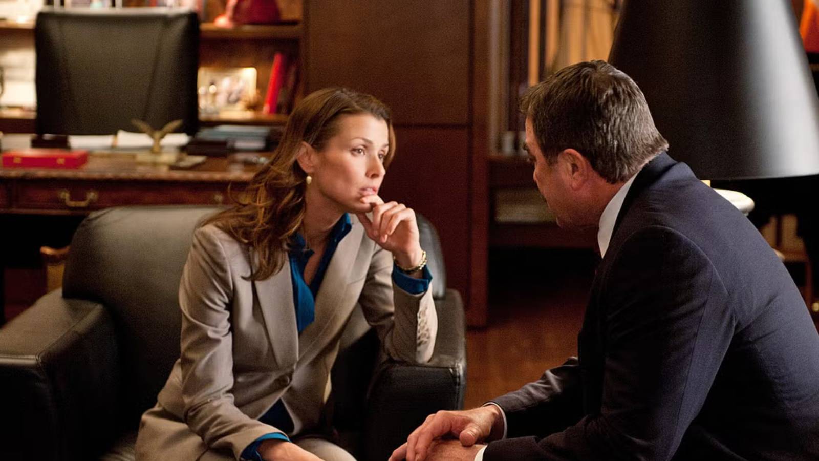 Blue Bloods Erin sitting in a leather chair leaning forward to talk to Frank