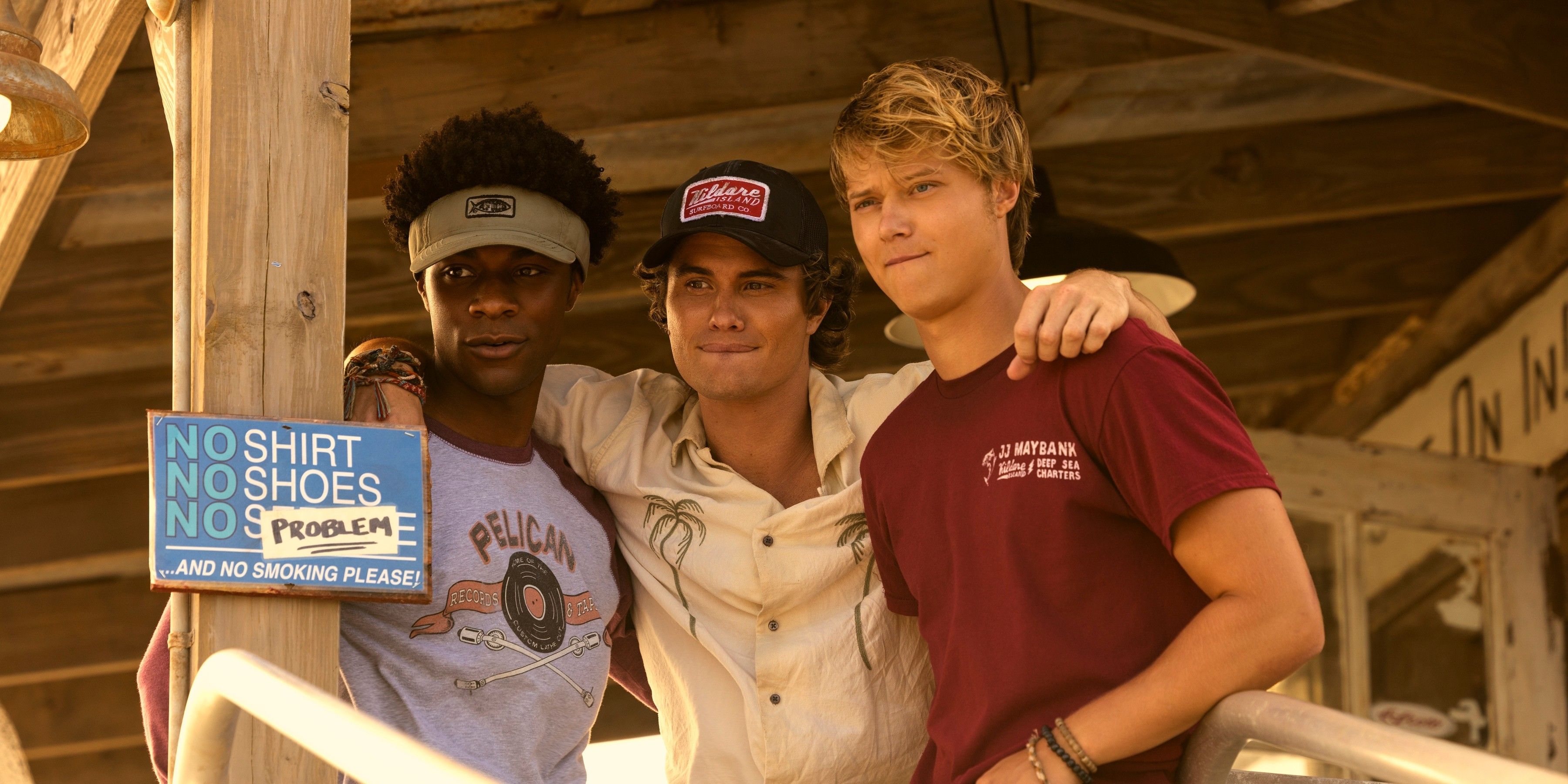 John B with his arms around Pope and JJ at the charter boat store in Outer Banks season 4