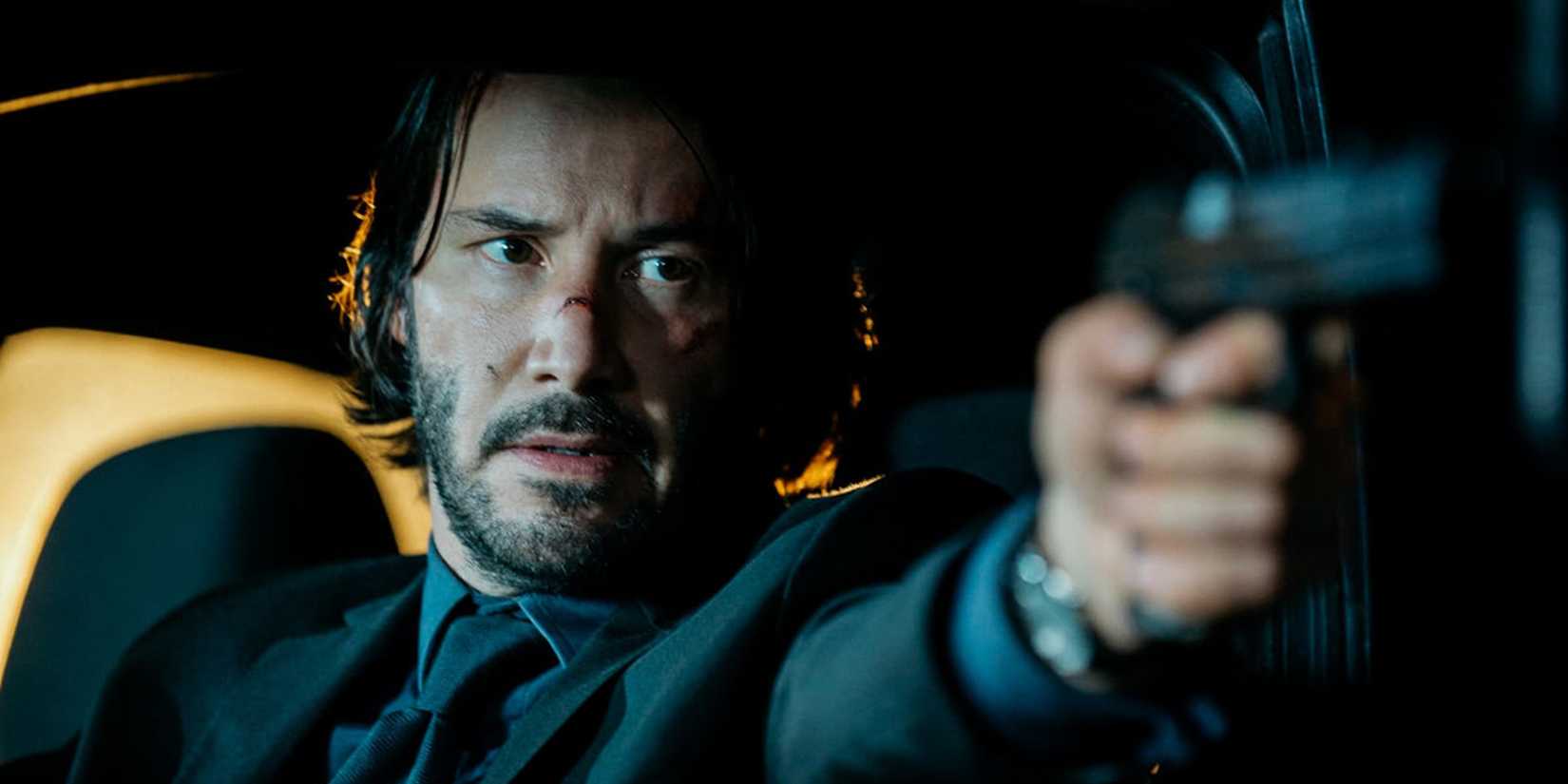 Keanu Reeves in a car with a gun in John Wick