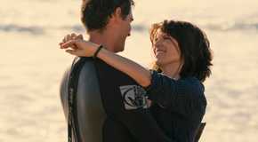 Maggie puts her arms around Mickey's neck by the ocean in The Lincoln Lawyer season 3 episode 1