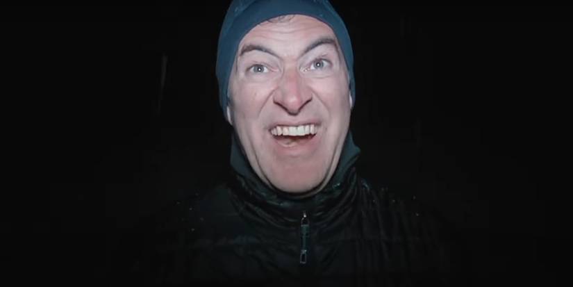 Mark Duplass' serial killer in winter gear standing in a darkened environment in The Creep Tapes