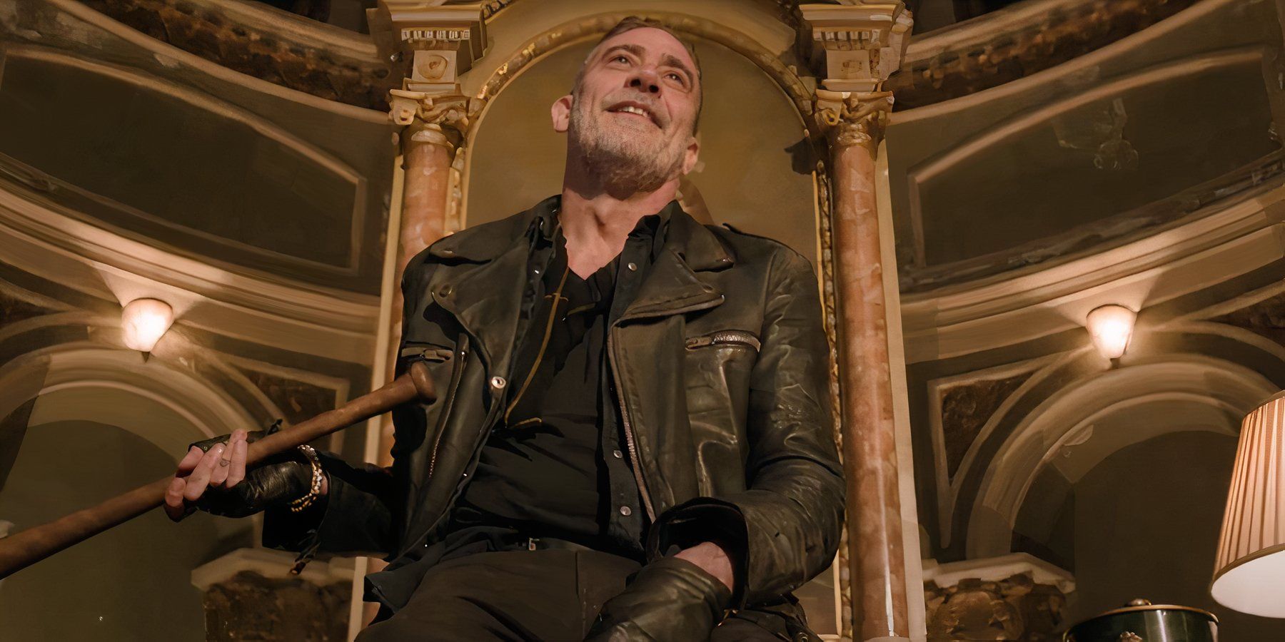 Negan sitting and smiling with Lucille in The Walking Dead: Dead City season 2.