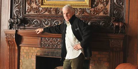 Steve Martin as Gavin Volure stood against the fireplace In 30 Rock