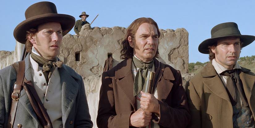 O Alamo de 2004, Davy Crockett e outros personagens de vestido de época conversando lá fora