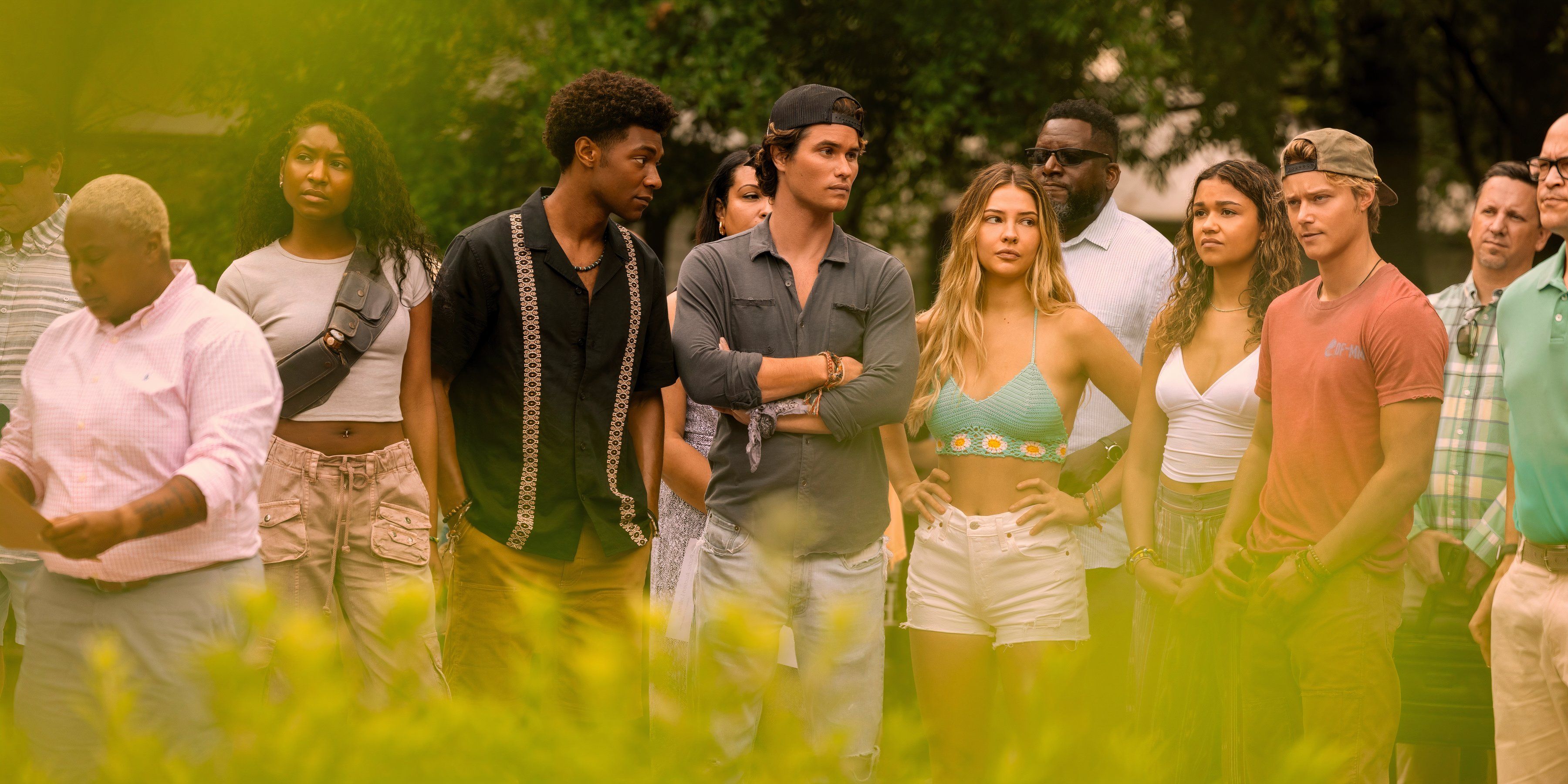 The cast of Outer Banks stand in a field in season 4