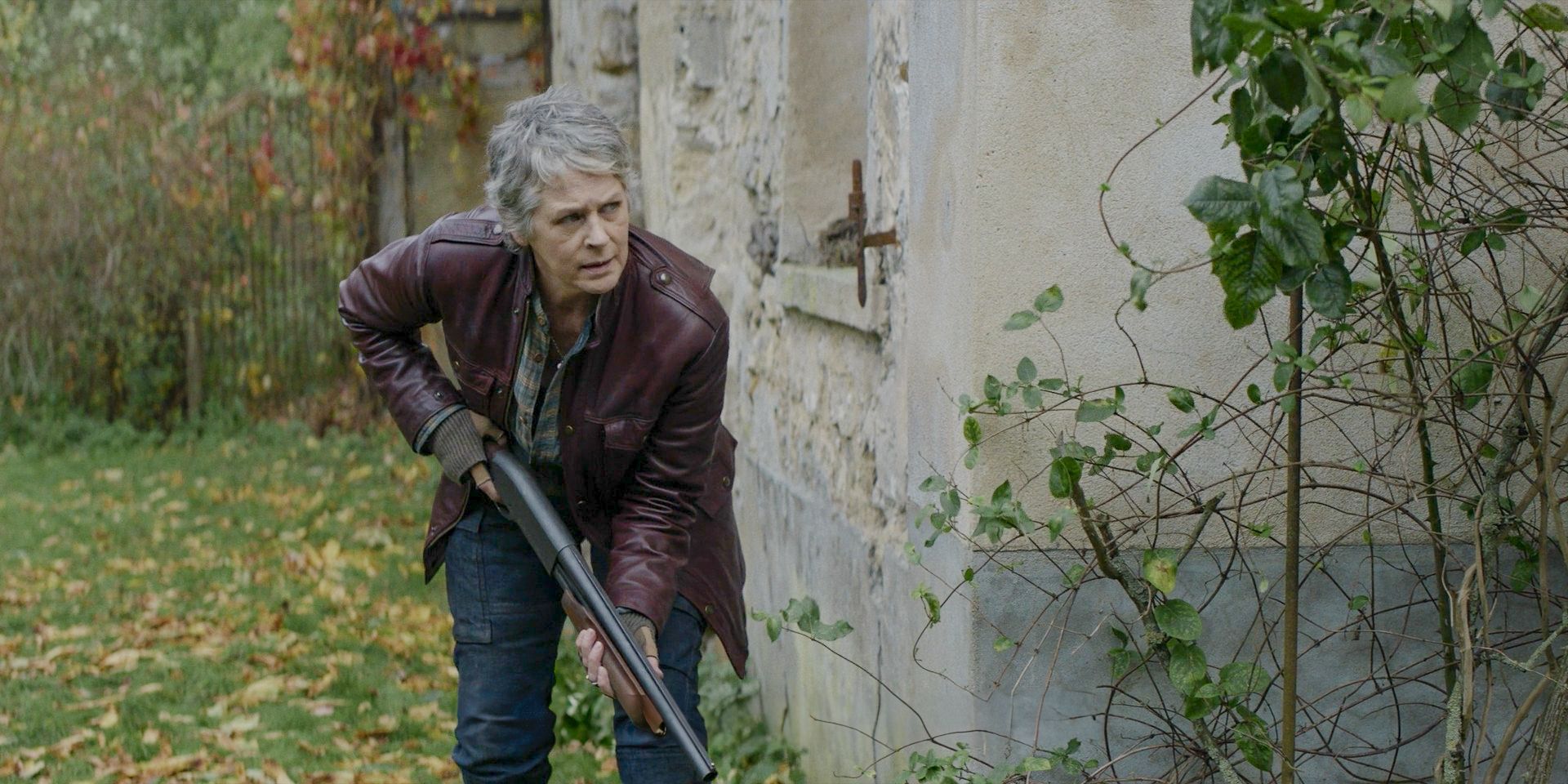 Melissa McBride as Carol sneaking while holding a shotgun in The Walking Dead: Daryl Dixon Season 2 Episode 4