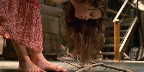 Summer Glau as River Tam in bending over and looking at a branch on the ground in the Firefly finale.