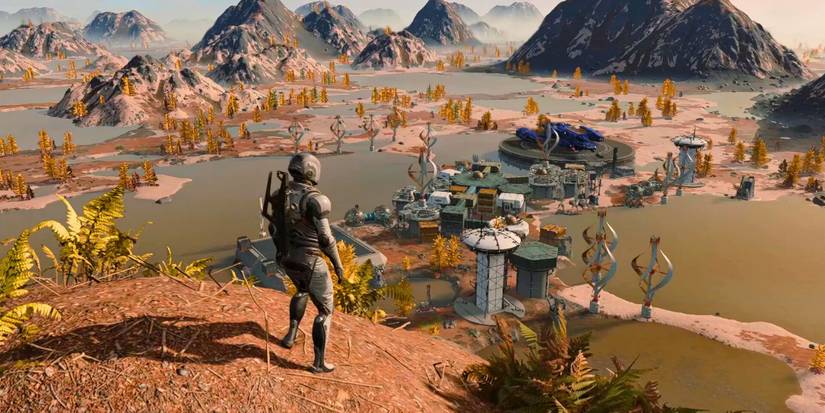 A Starfield player standing on top of a hill, looking down at an outpost that also includes a purple ship.