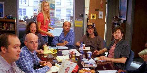 Writers gathered at the table in the writers room in 30 Rock