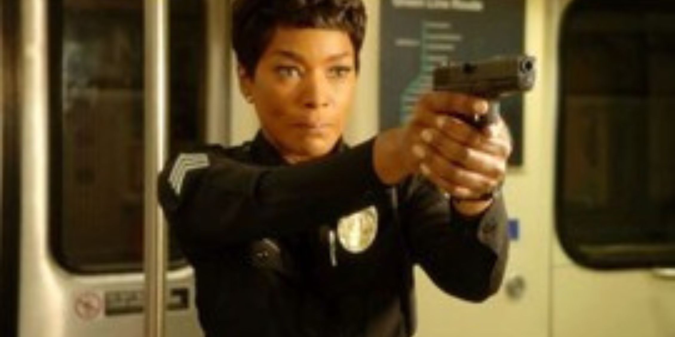 9-1-1 Athena standing in a subway car pointing a gun