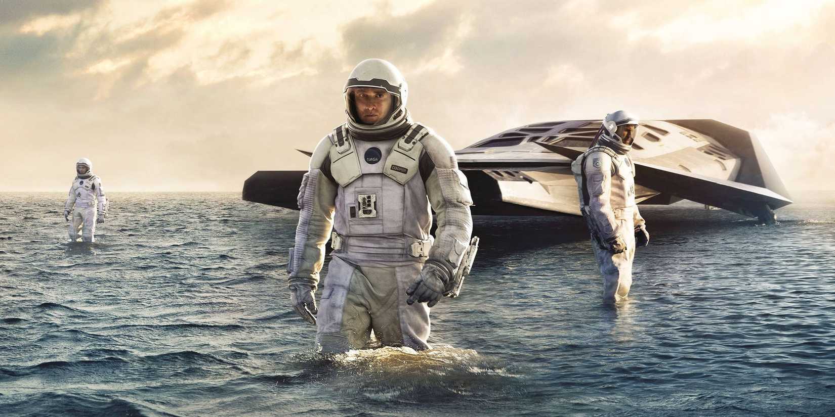 Astronautas caminhando na água em uma imagem promocional de Interstellar