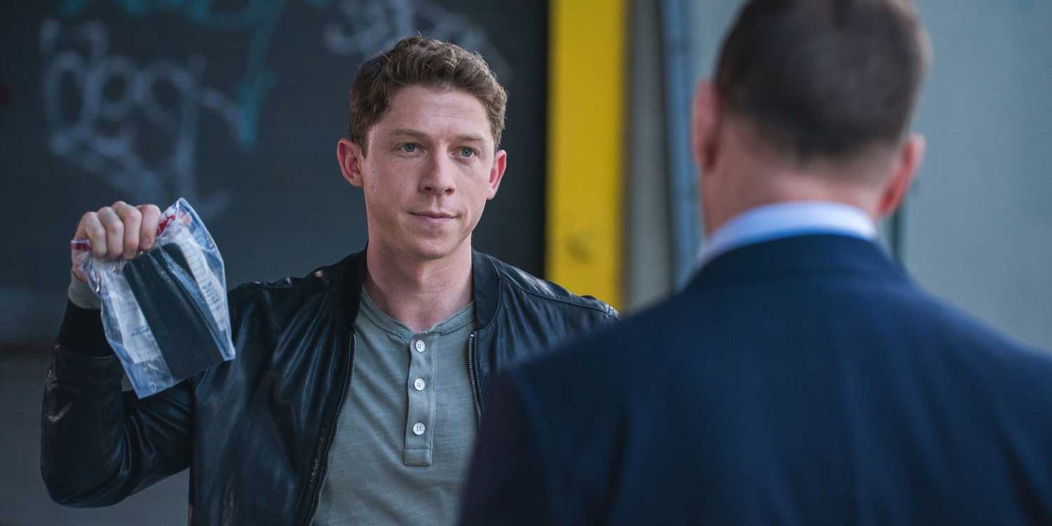 Blue Bloods Joe Hill triumphantly holding up a cell phone in an evidence bag while talking to Danny