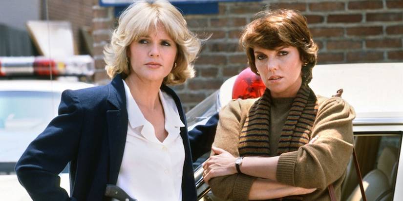 Cagney and Lacey standing in front of cars
