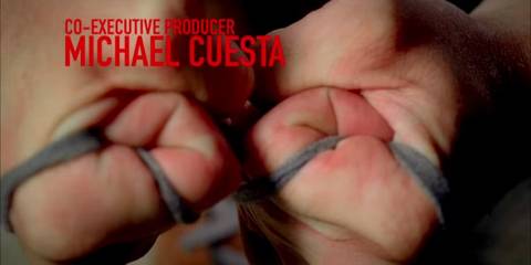Dexter's hands are pictured gripping tightly as he ties his shoe laces, giving the impression of bound hands.