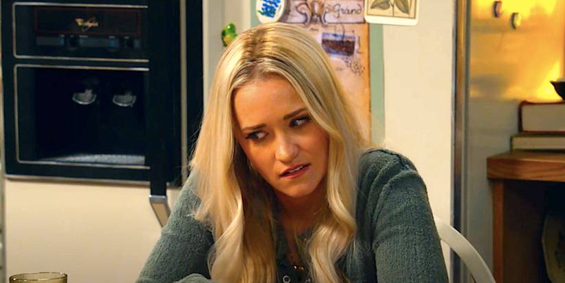 Emily Osment's Mandy looking embarrassed sitting at a kitchen table in Georgie & Mandy's First Marriage