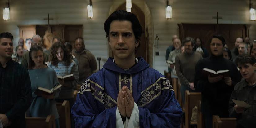 Father Paul (Hamish Linklater) walking down an aisle at mass in Midnight Mass