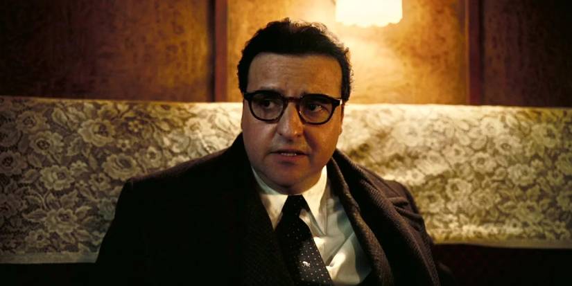 Isidor Isaac Rabi (David Krumholtz) talking to someone in a train car in Oppenheimer.