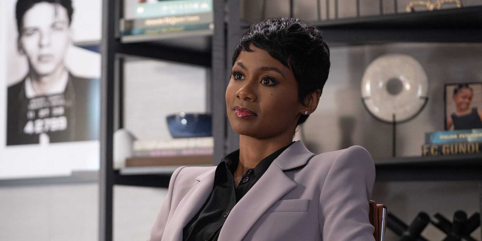 Jax sentada em sua mesa em Reasonable Doubt