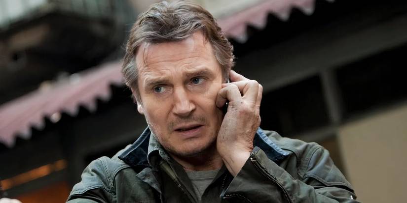 Liam Neeson on the phone looking concerned in Taken.