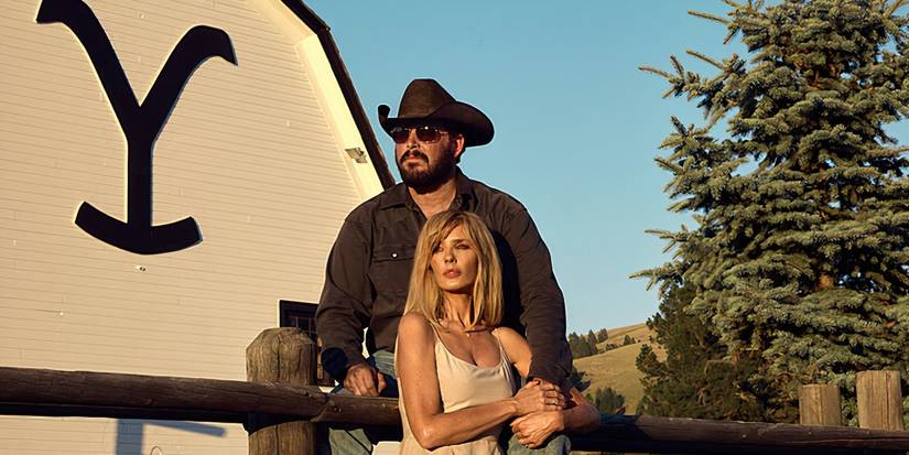 Rip and Beth sitting on the cow pen fence in front of the barn in Yellowstone season 5 part 2