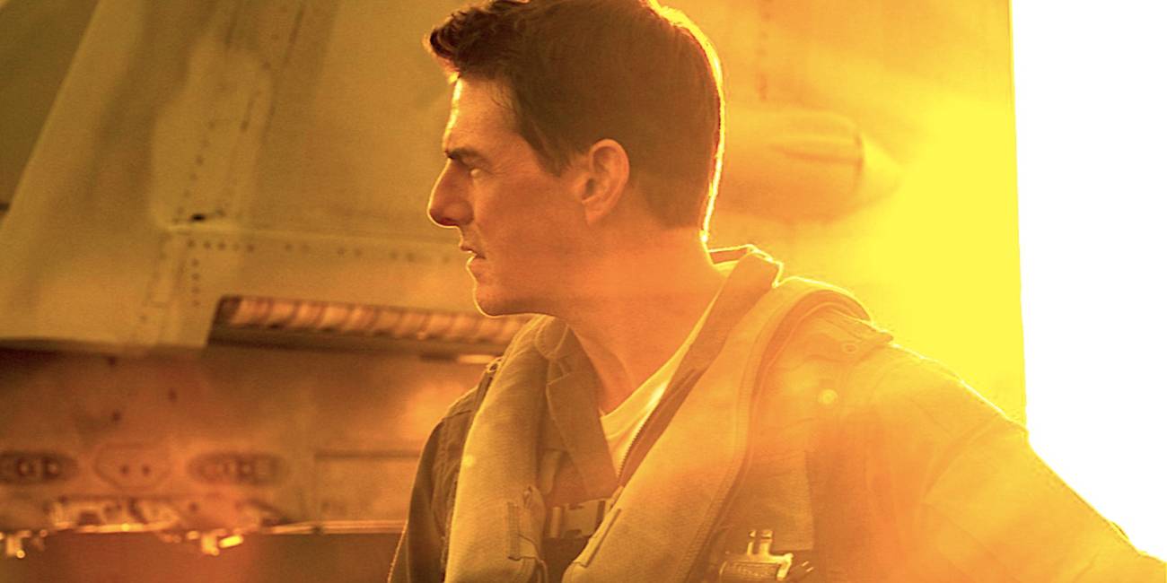 tom cruise s maverick stands beside a plane in top gun maverick