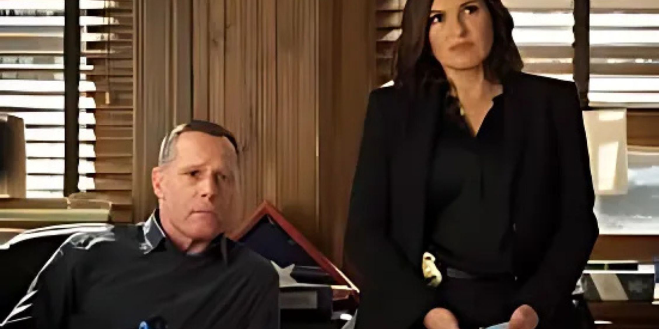 Hank Voight sitting next to Olivia Benson in her office in Law & Order: SVU